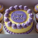birthday bento cake with purple frosting and cupcakes in white box